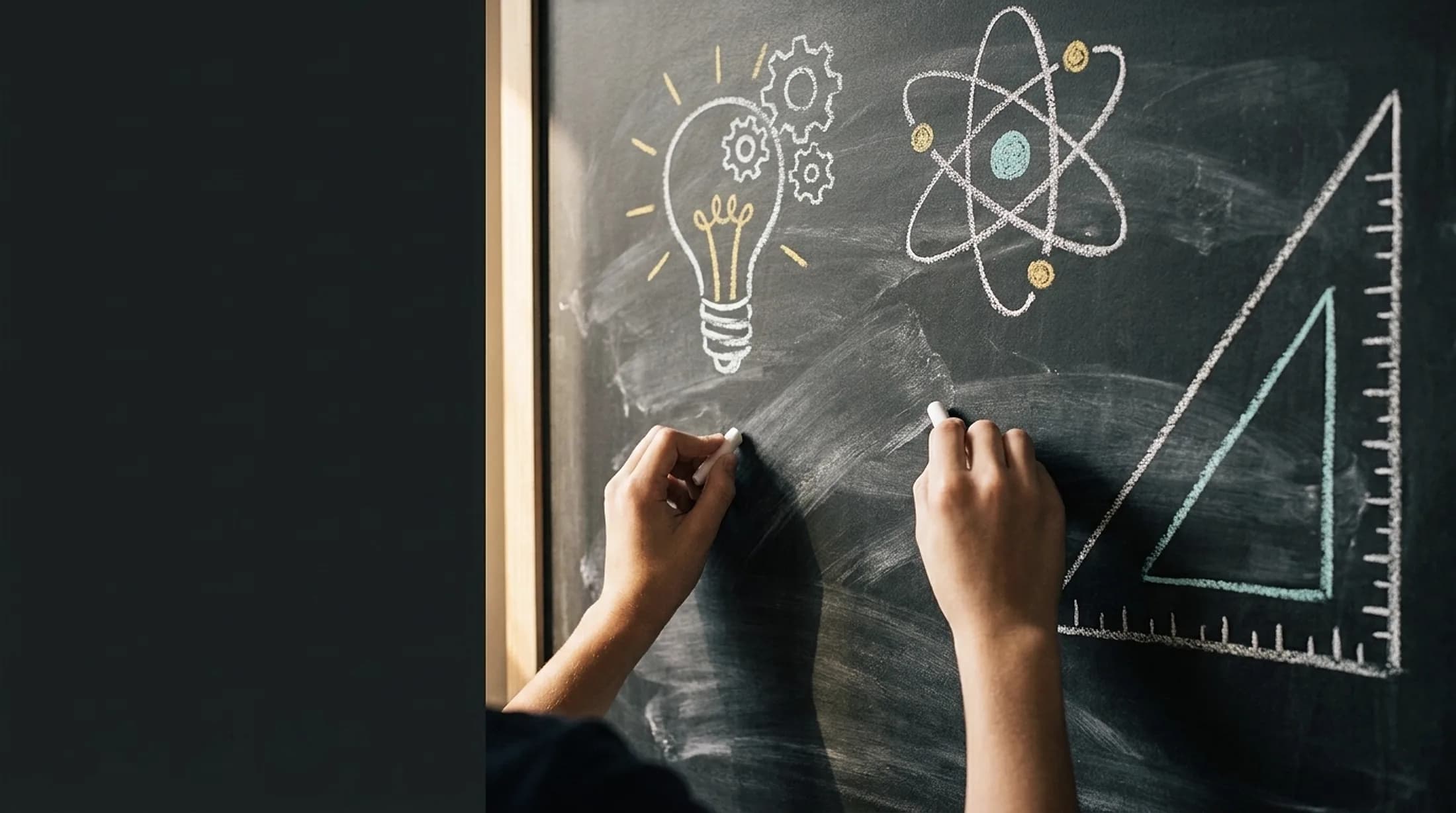 Hands writing with chalk on a blackboard